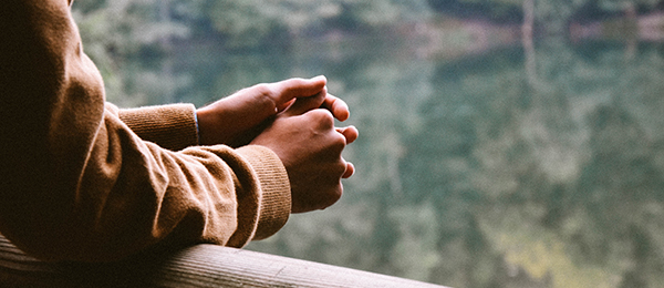 OLC - a man's hands on a railing in thought